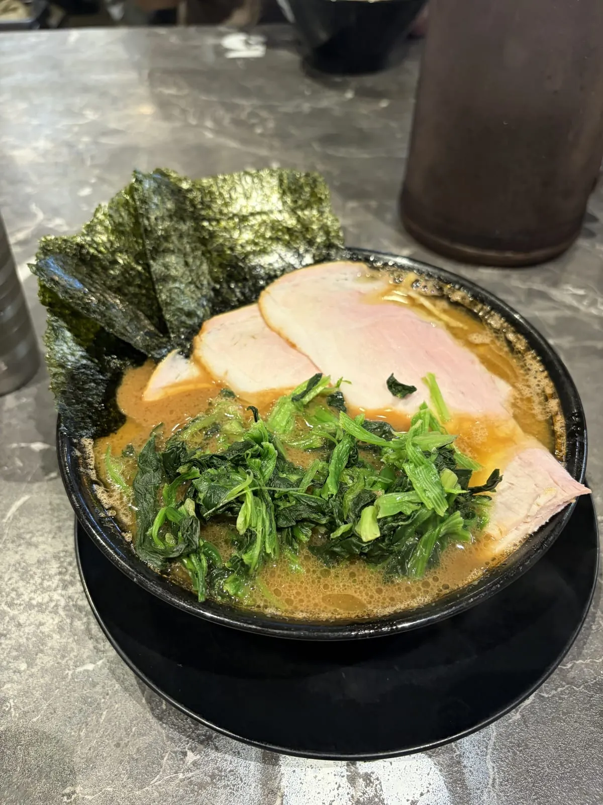 王道家直系ラーメンがくのチャーシュー麺。黒い丼の醤油豚骨スープに大判のチャーシュー3枚、ほうれん草、海苔
